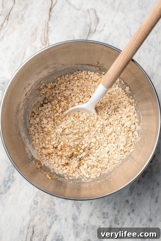 Homemade Chewy Pecan, Raisin and Chocolate Chip Granola Bars 6 Stirring dry ingredients in bowl for granola bars.