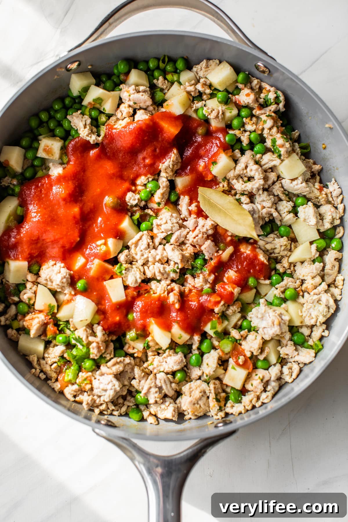 skillet with ground turkey, peas, tomatoes and potatoes