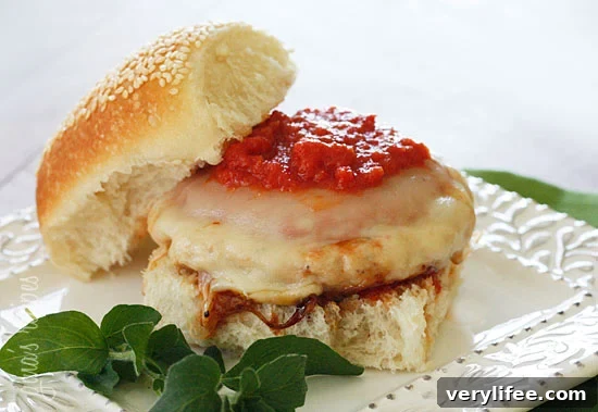 A chicken parm burger on a white plate