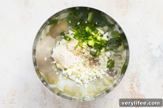 Eggs, mayo, scallions in a bowl.