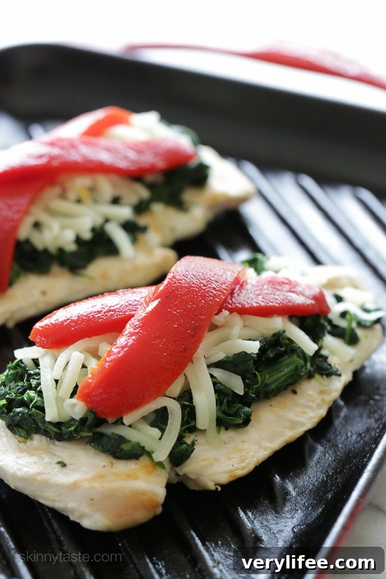Grilled Chicken with Spinach and Melted Mozzarella Recipe 5 Grilled chicken on a grill pan topped with sauteed garlicky spinach, mozzarella and roasted peppers