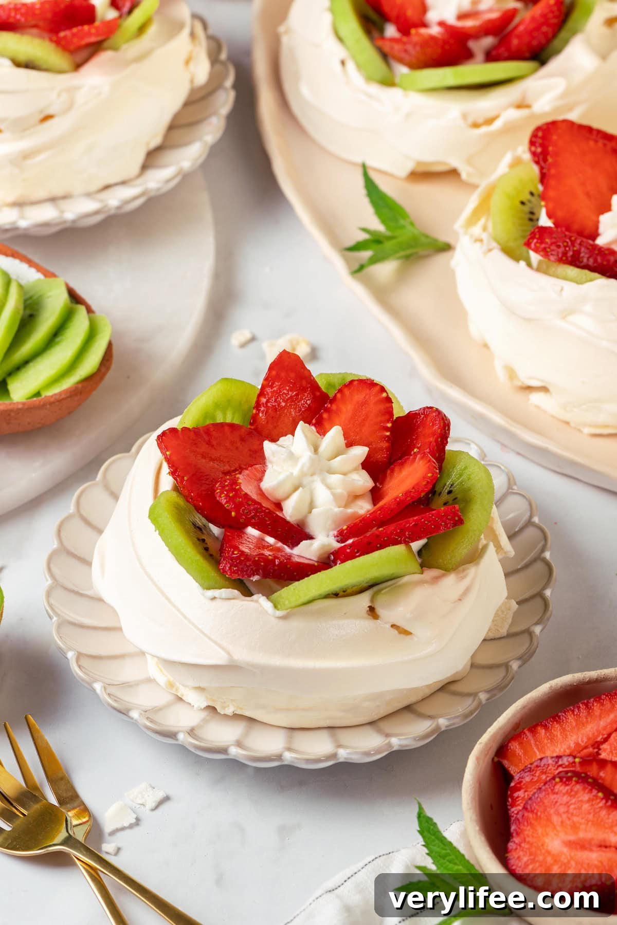 Strawberry kiwi pavlova ready to serve Strawberry kiwi pavlova on plates and platter