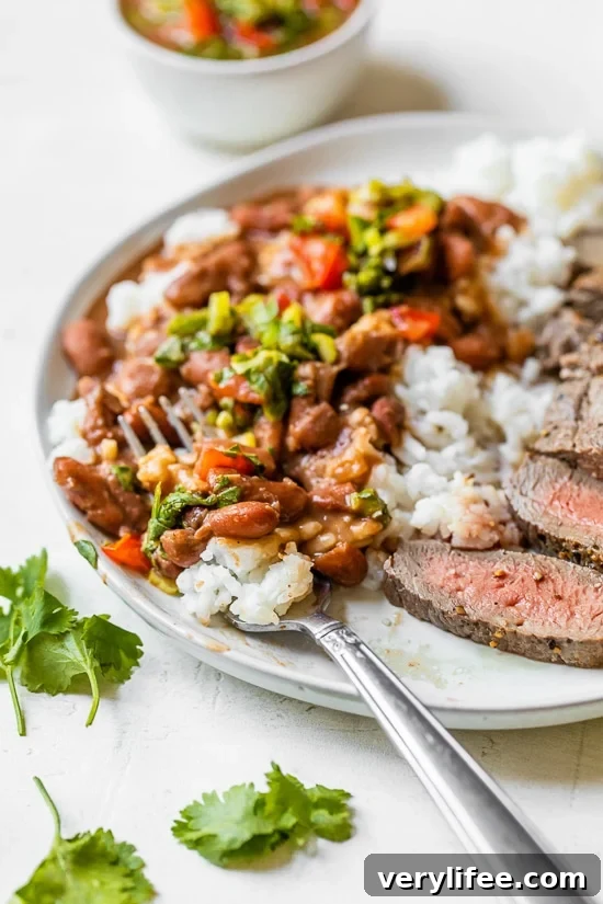 Dominican Beans over rice with aji picante on top and steak on the side.