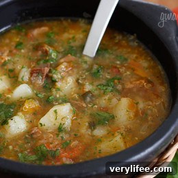 Hearty Beef, Potato and Quinoa Soup Recipe 2 A bowl of beef, potato and quinoa soup, garnished with cilantro.