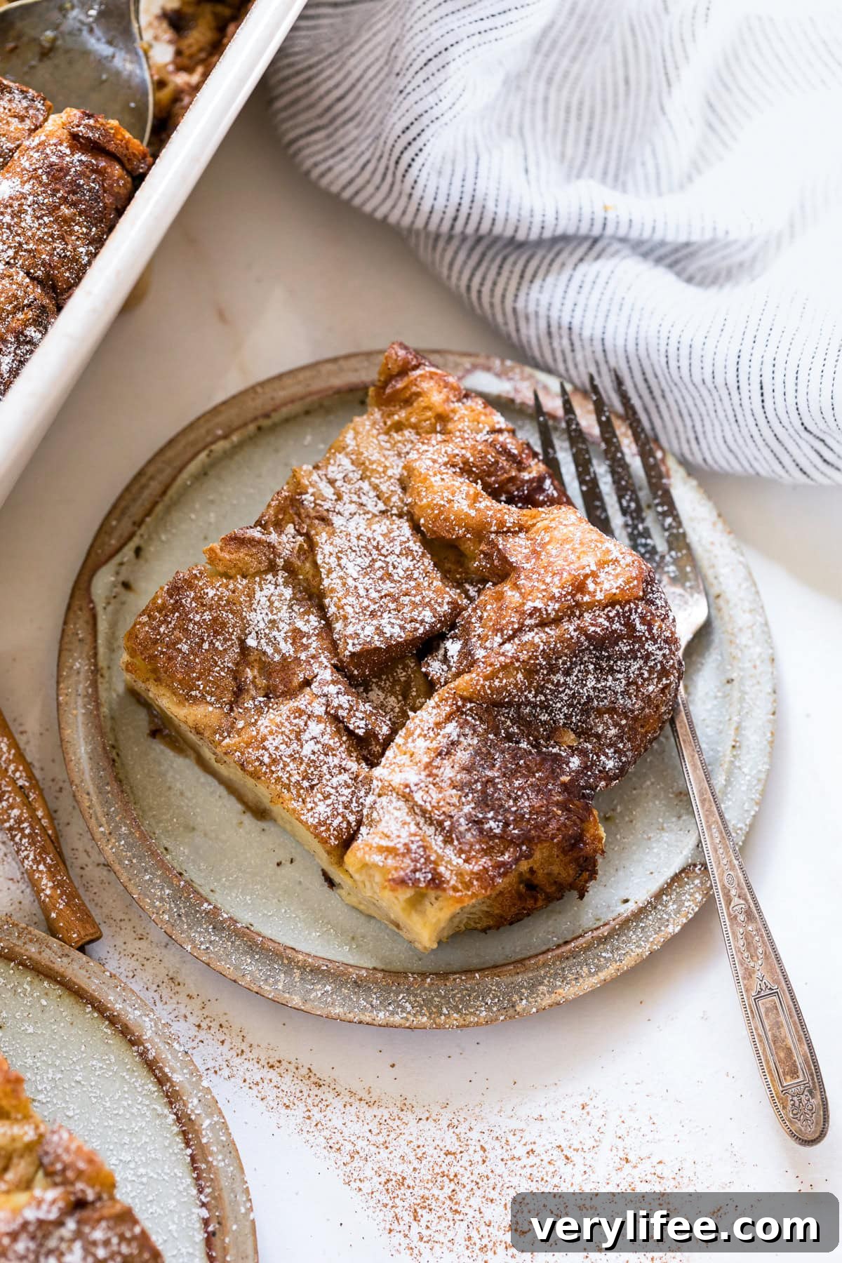 A slice of overnight creme brulee French toast on a plate with a fork.