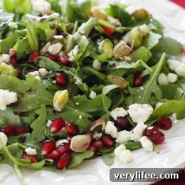 Arugula salad topped with pomegranate arils, blue cheese and pistachios