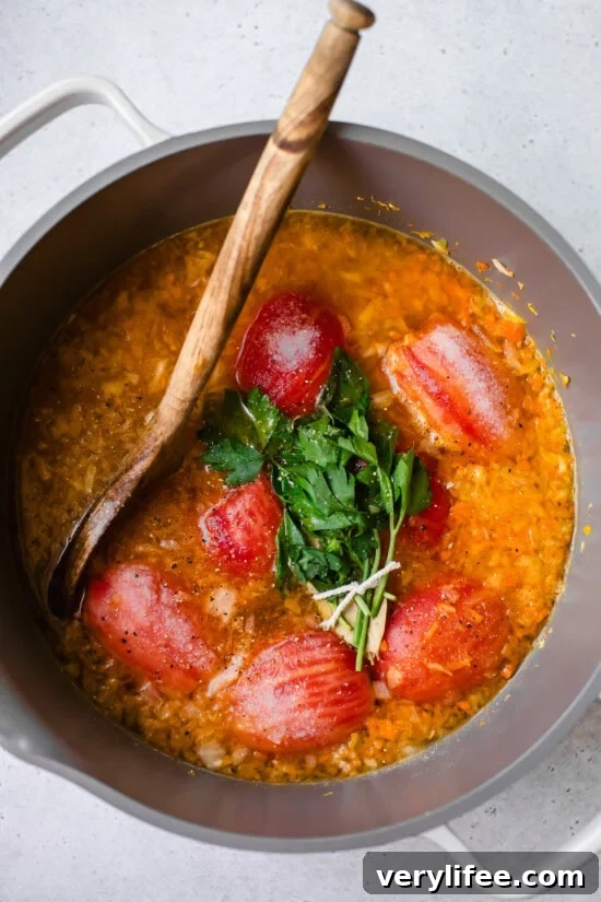 peeled tomatoes and herbs in pot