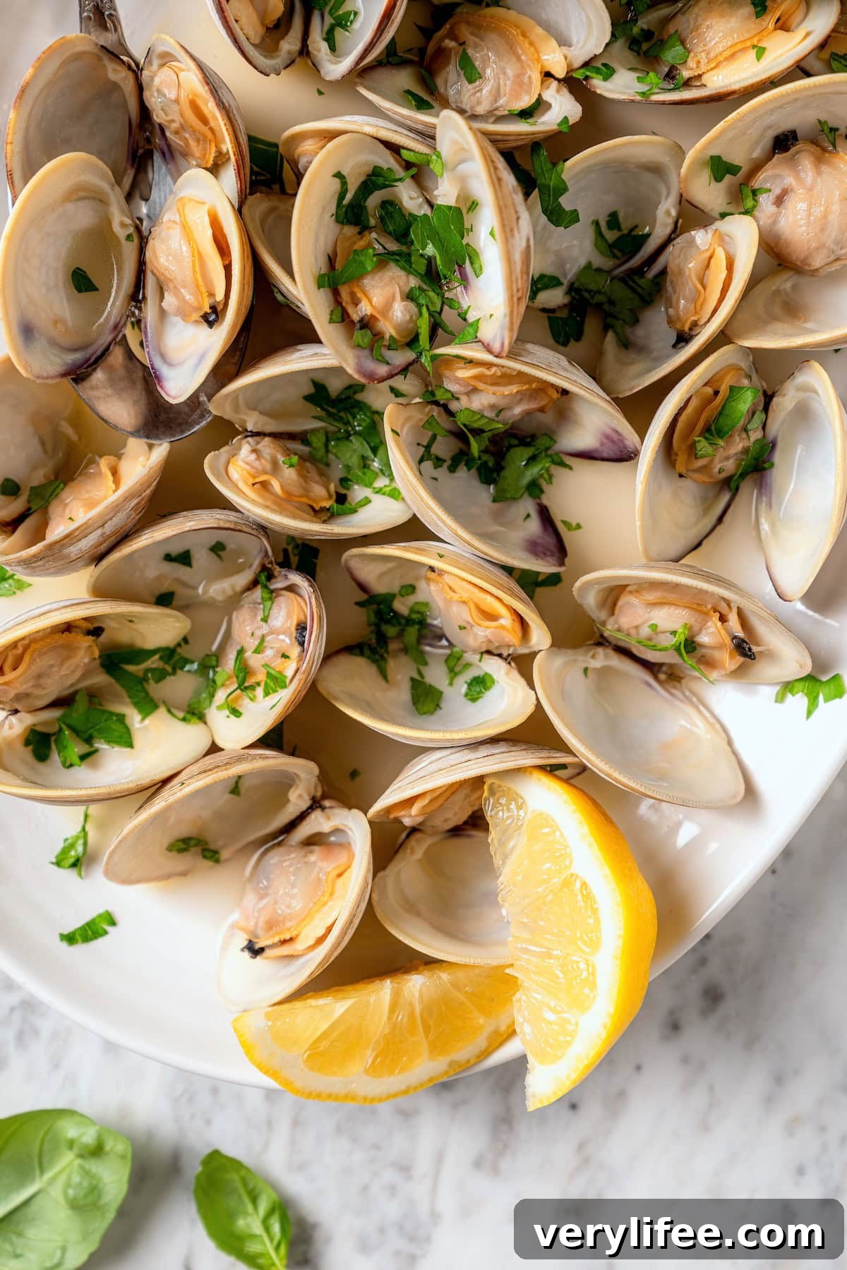 Tender Steamed Clams with Garlic and White Wine 12 Platter of steamed clams with lemon wedges.
