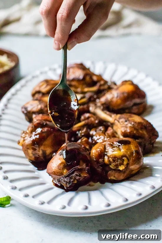 Sticky Asian Glazed Chicken Drumsticks Recipe 6 Spooning sauce on Asian chicken drumsticks