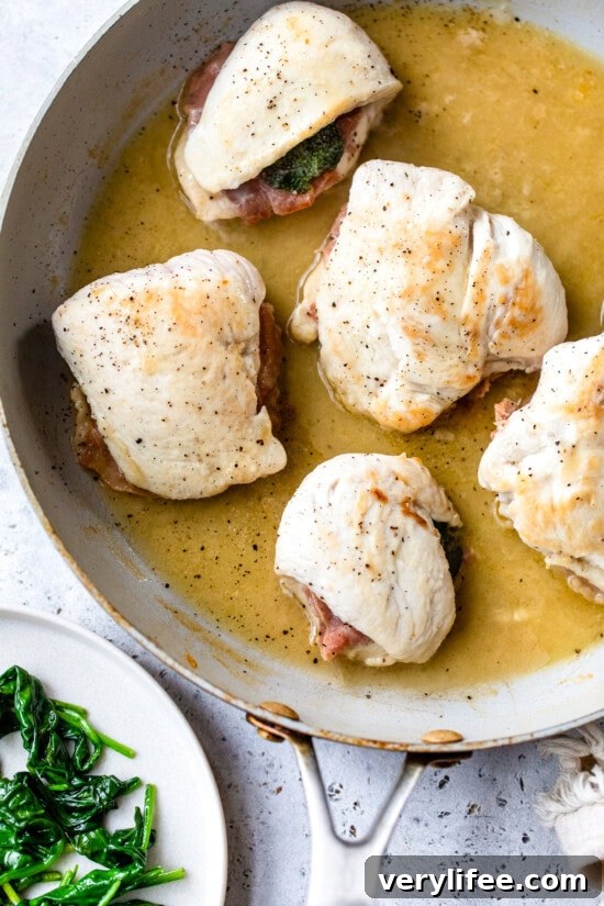 Chicken saltimbocca cooking in skillet with white wine sauce