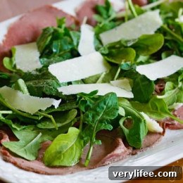 Classic Beef Carpaccio Recipe with Arugula and Parmesan 3 Beef carpaccio on a plate with arugula and shaved cheese