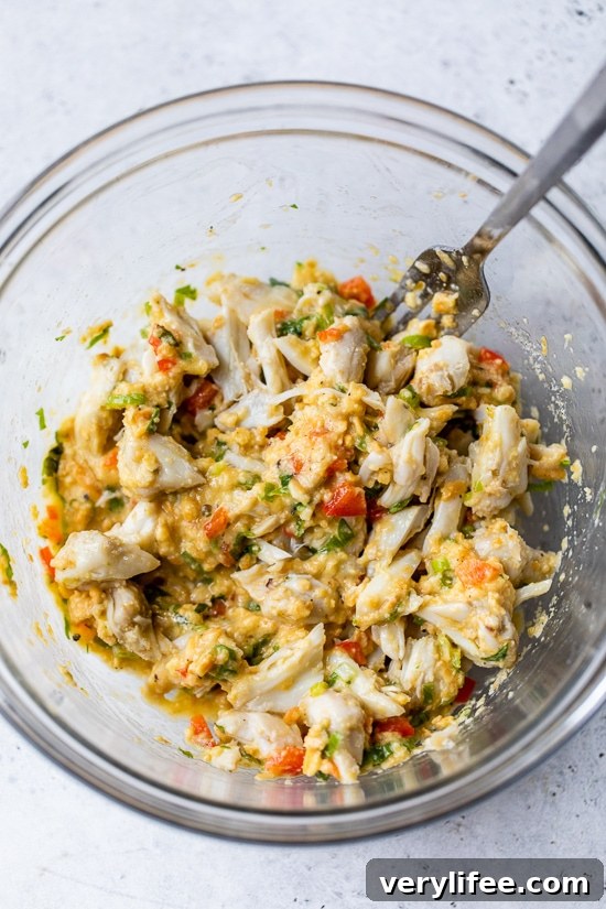 Fold in crab meat Crab cake ingredients combined in a bowl.