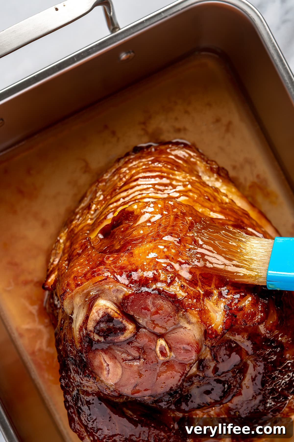 brushing honey glaze on ham