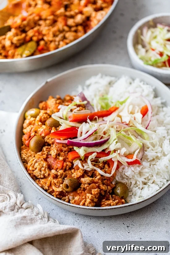 Turkey Picadillo with rice and slaw on a plate.