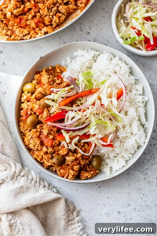 Picadillo with rice and slaw on a plate.