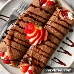 Two chocolate crepes filled with strawberries and whipped cream.
