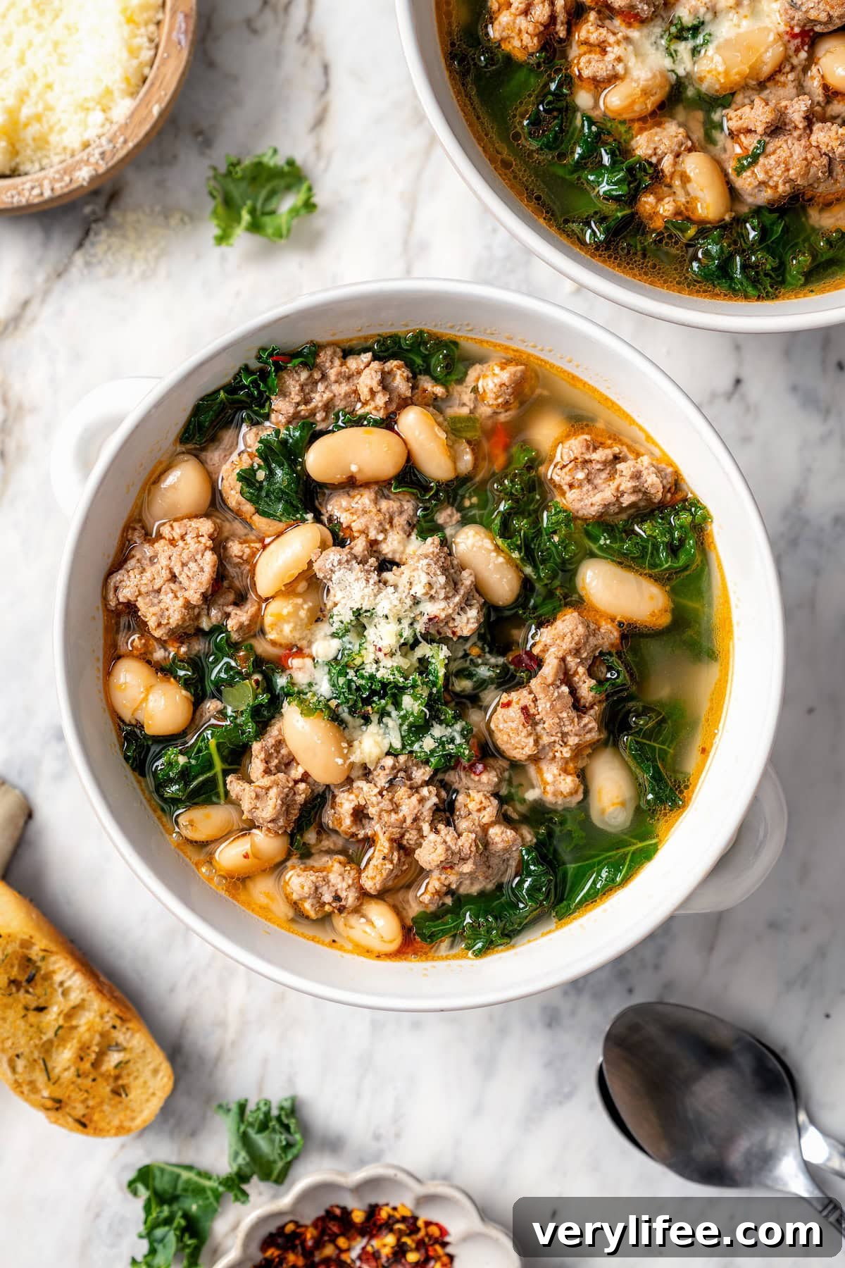 Bowl of white bean soup with sausage and kale.