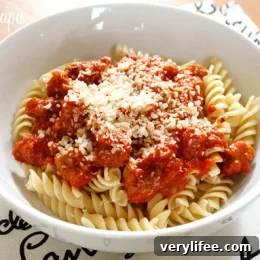 Pasta topped with turkey sausage and tomato sauce, garnished with torn fresh basil