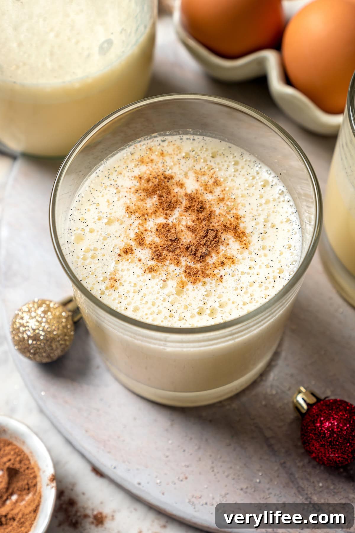 Top-down view of eggnog in glass with grated nutmeg on top