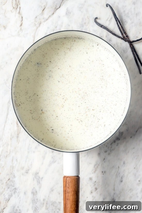 Milk and vanilla beans in pan