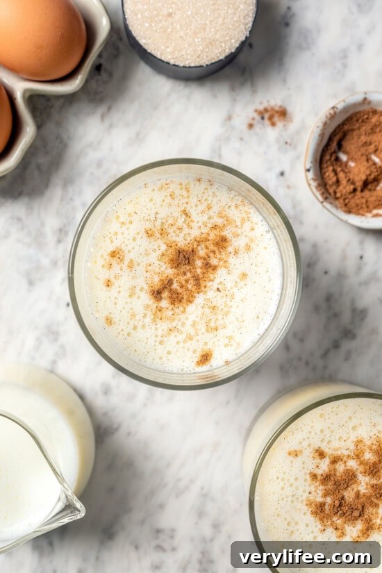 Overhead view of homemade eggnog in glass with grated nutmeg on top