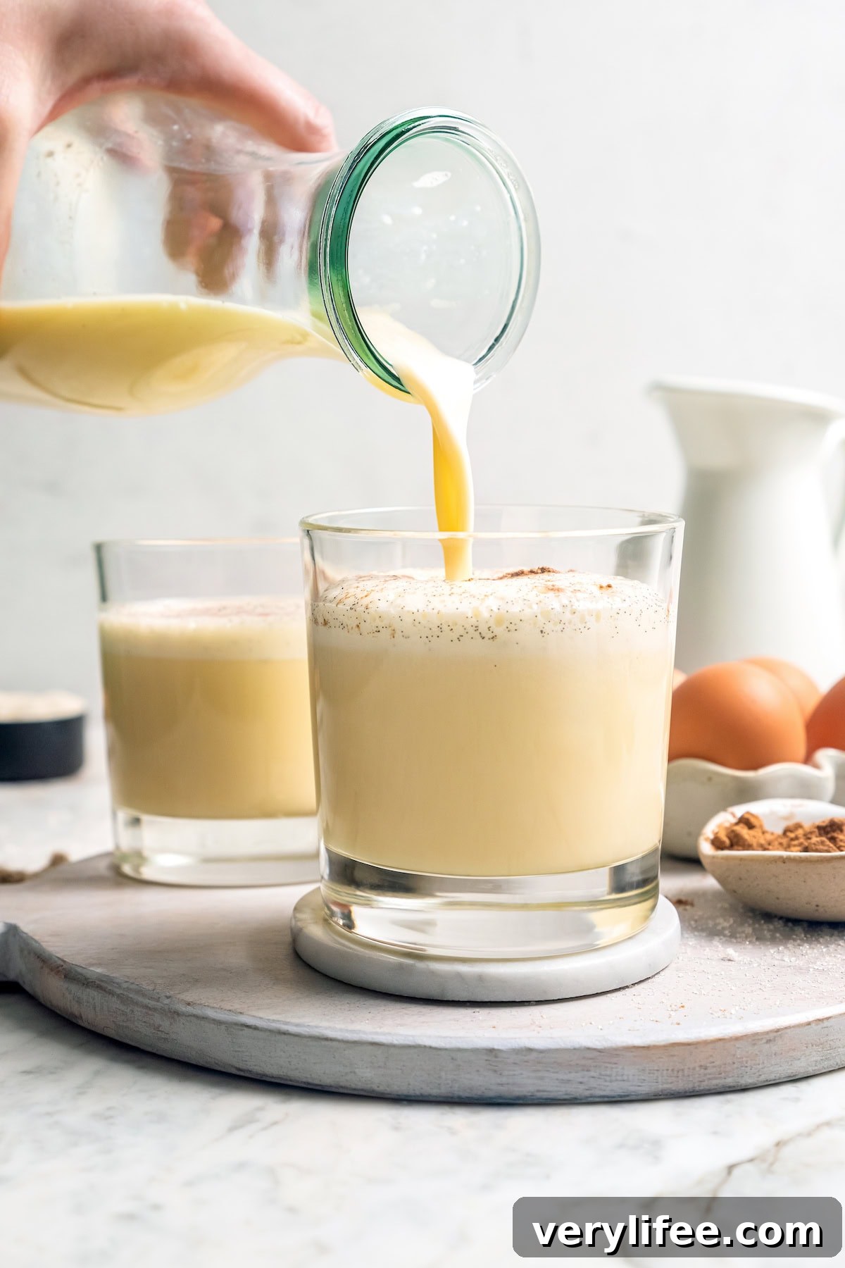 Pouring homemade eggnog into glass