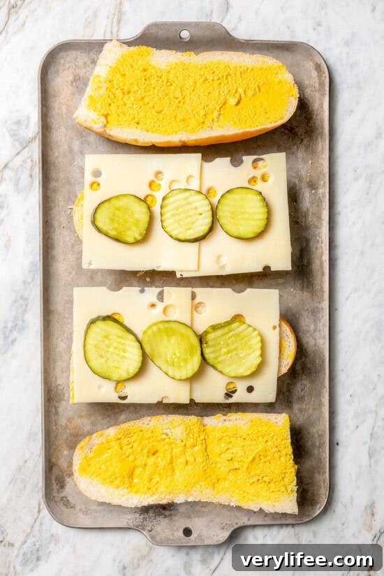 Pickles and cheese layered onto Cuban sandwiches