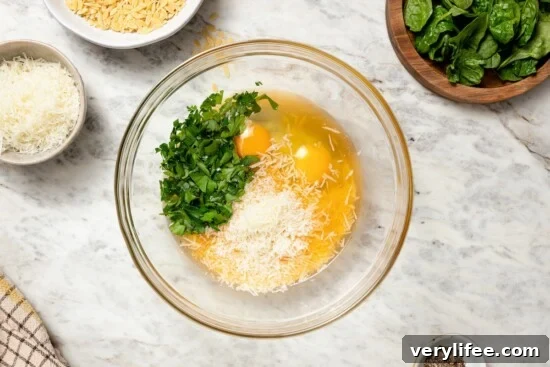 Classic Italian Stracciatella Soup with Spinach and Orzo 5 Eggs, Parmesan, and parsley in glass bowl.