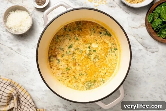 Classic Italian Stracciatella Soup with Spinach and Orzo 7 Pot of stracciatella soup before adding spinach.