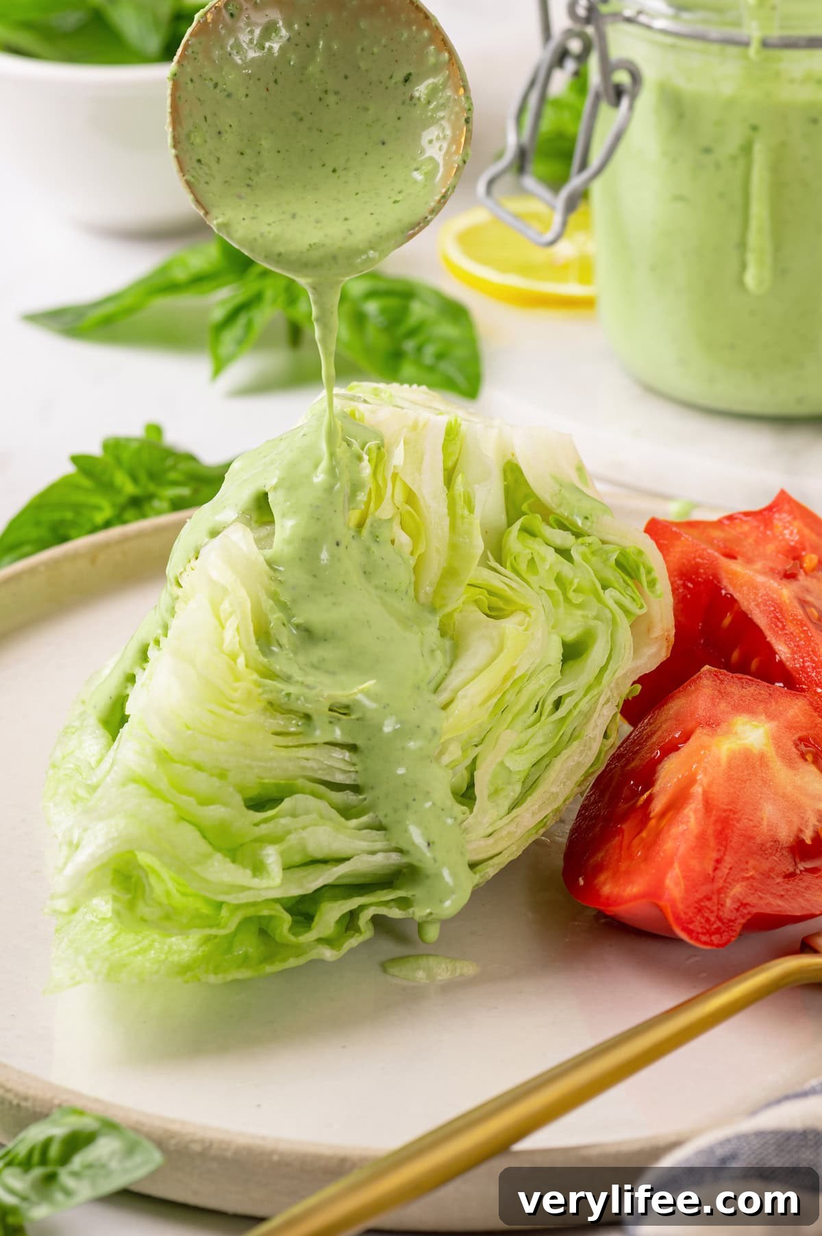 Drizzling basil green goddess dressing over wedge salad