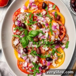 Overhead view of heirloom tomato salad with basil and kalamata olives