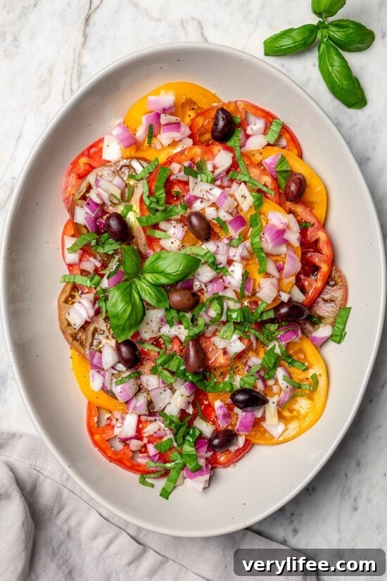 Overhead view of heirloom tomato salad with basil and kalamata olives