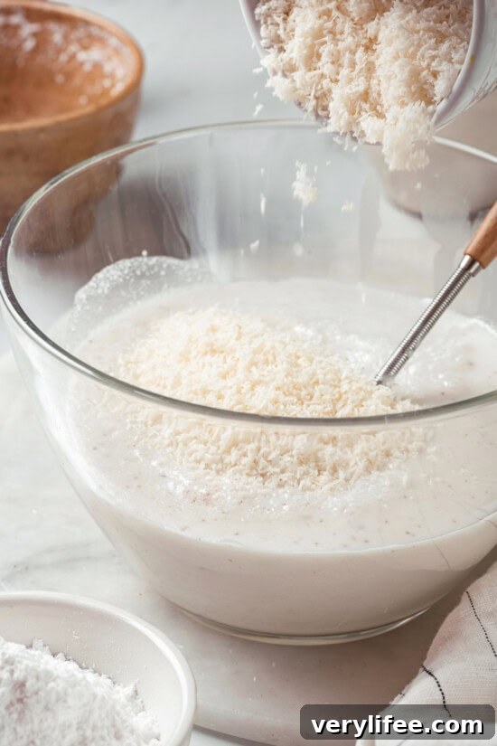 Combine ingredients in a bowl. Adding shredded coconut to popsicle mixture in bowl