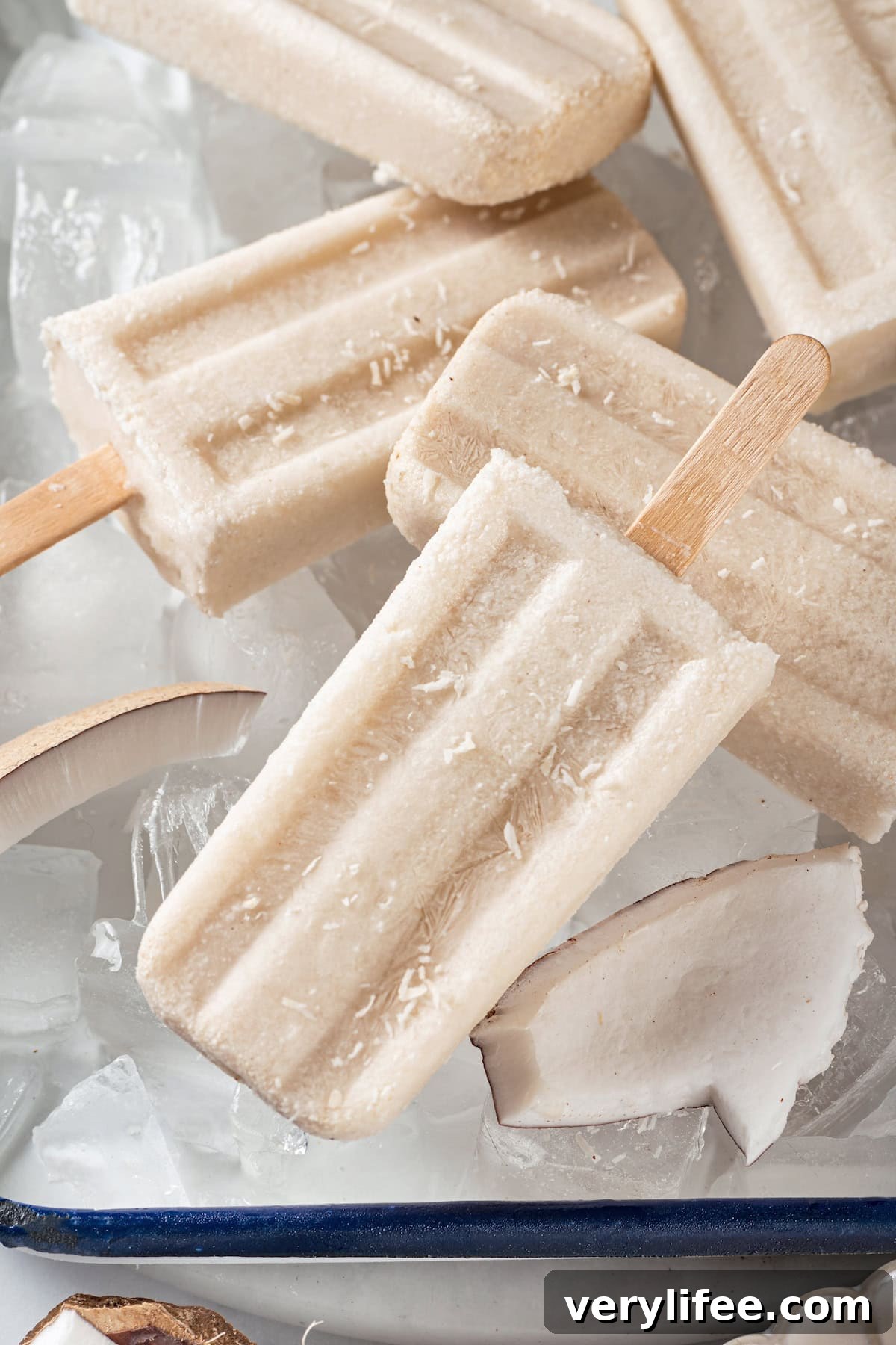 Coconut popsicles on ice. Homemade coconut popsicles on ice with coconut pieces