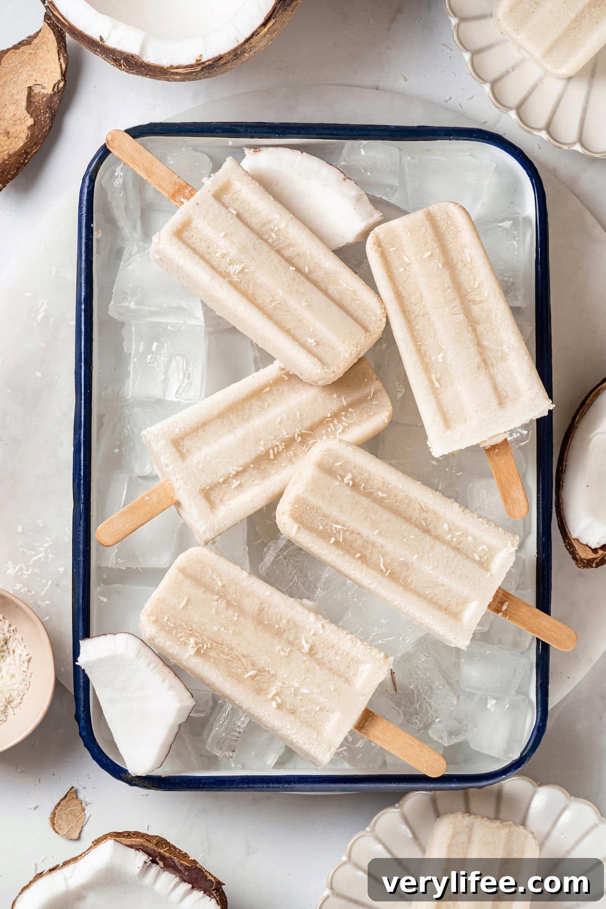 Coconut popsicles in a pan of ice. Overhead view of coconut cream pops in pan of ice