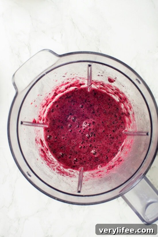 Blend the blueberries until smooth or leave chunky if preferred. Overhead view of pureed blueberry mixture in blender