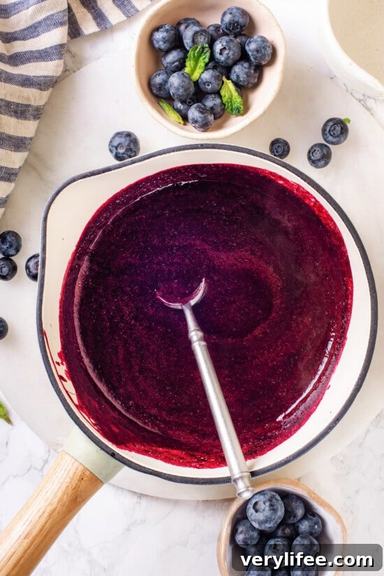 Cook the compote until it thickens and coats a spoon. Overhead view of blueberry compote in saucepan