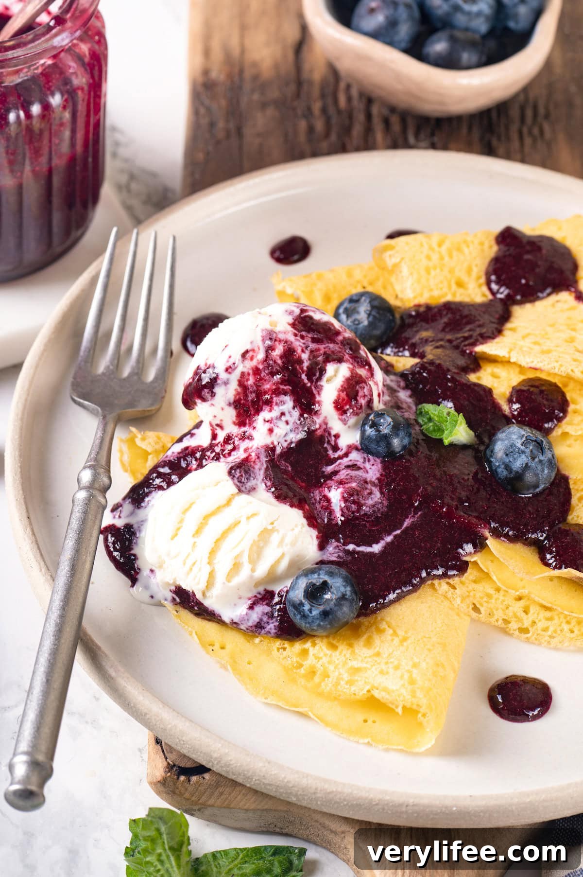 Use compote on crepes, pancakes, and desserts. Plate of crepes with ice cream and blueberry compote