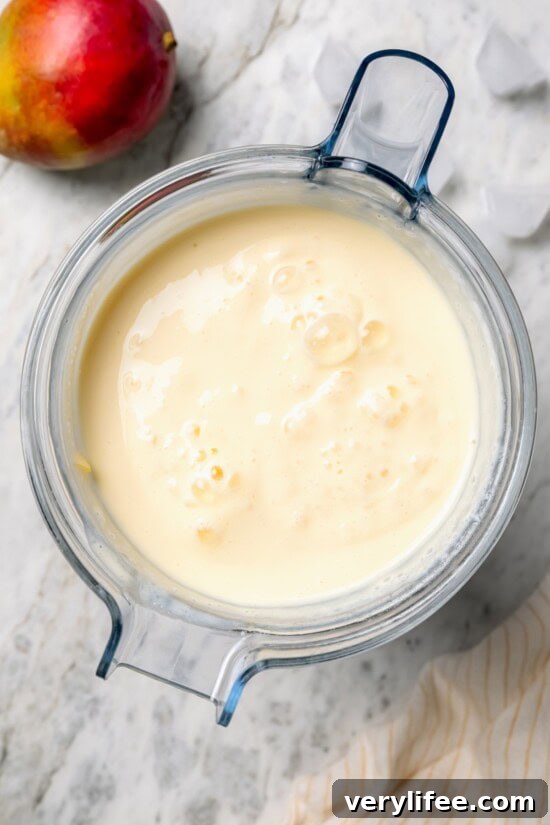 Overhead view of mango lassi in blender