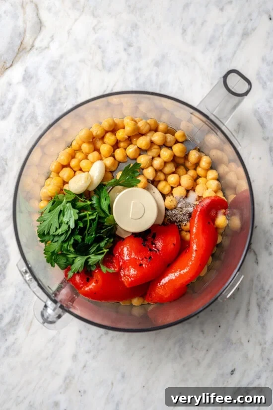 Overhead view of ingredients for roasted red bell pepper hummus in food processor