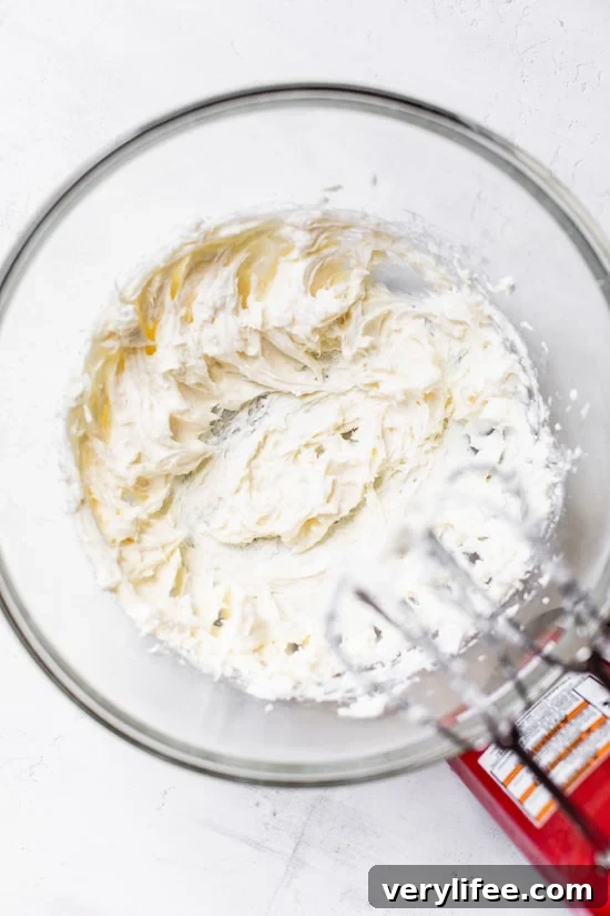 Beat the filling until smooth and fluffy Beating no-bake cheesecake filling in mixing bowl