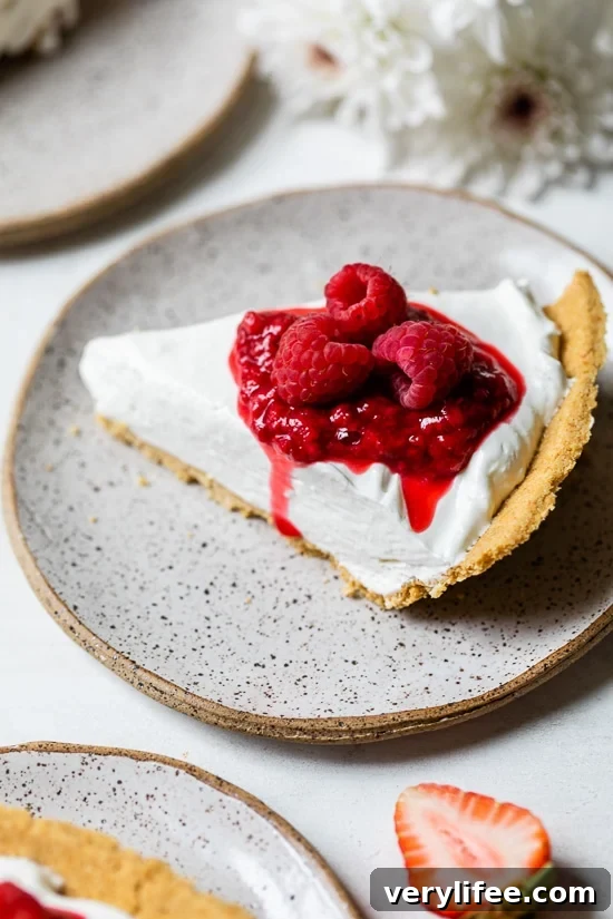 No-Bake Cheesecake slice with raspberries Slice of creamy no-bake cheesecake topped with macerated and fresh raspberries
