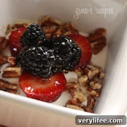 Greek yogurt bowl topped with fresh berries, chopped nuts and honey