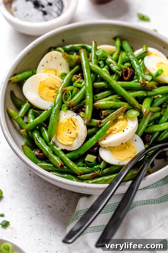 Green bean salad in bowl with two forks.