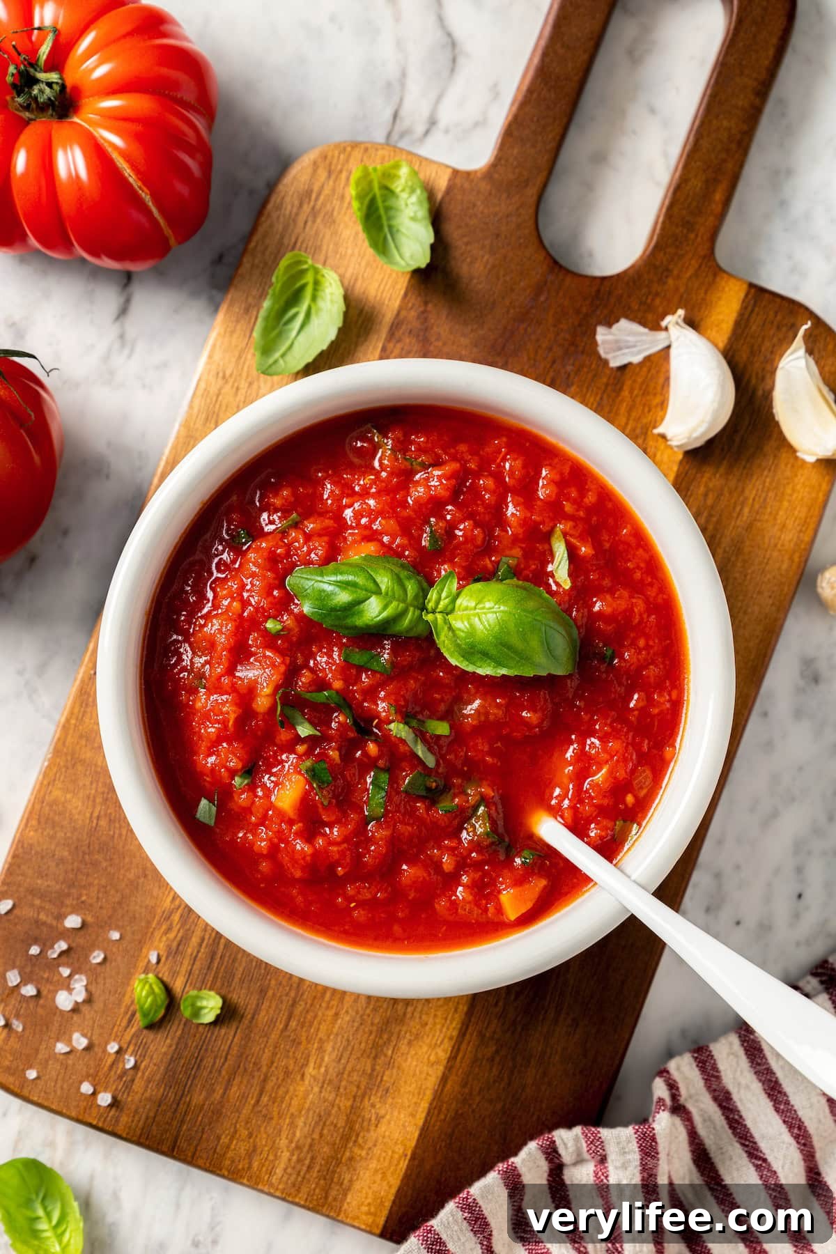 Bowl of filetto di pomodoro sauce with spoon.
