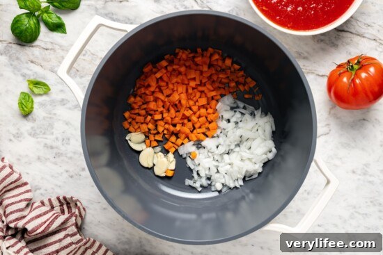 Carrots, onion, and garlic in pot.