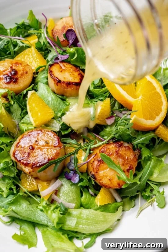Pouring mojo vinaigrette onto scallop salad