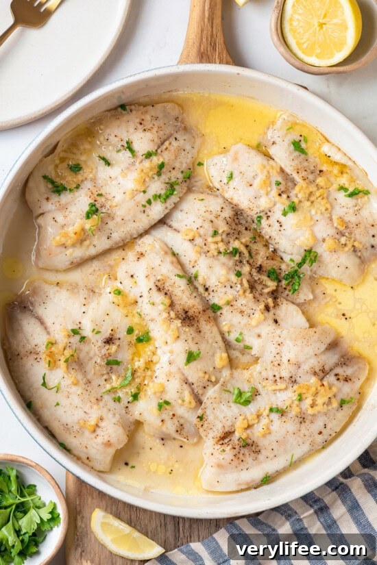 Crispy Oven Baked Tilapia with Lemon and Herbs 5 Overhead view of baked tilapia in skillet