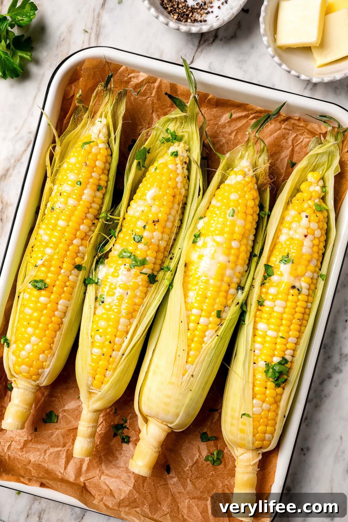 Once you try this microwave corn on the cob recipe, you may never go back to boiling! It's quick, easy, and cleanup is a breeze. Microwave corn on the cob on parchment-lined pan.
