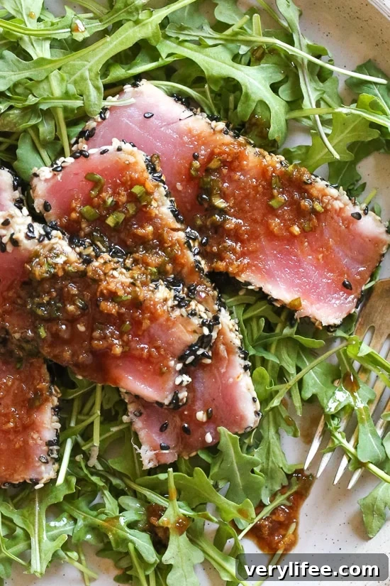 Sesame Crusted Tuna Steak on Arugula drizzled with a balsamic soy-ginger vinaigrette – yum!